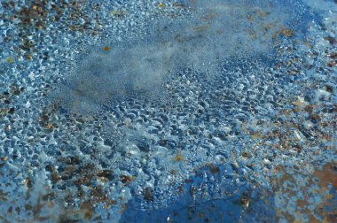 Paslı demir bir varil üzerinde yatan cam altında su buharı