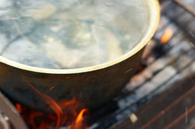 Balık çorbası ve grayling şenlik ateşinde büyük bir kapta pişirilir.
