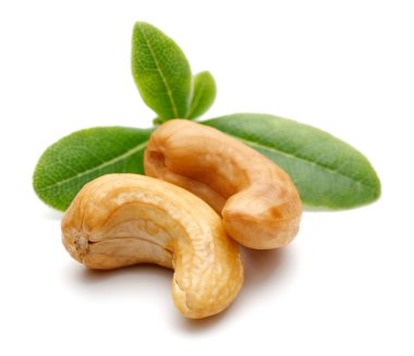 Beyaz arka plan üzerinde izole yeşil yaprakları ile kavrulmuş kaju fıstığı