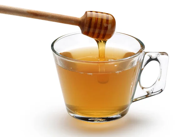 木製ディッパーからリンデン茶白い背景で隔離のカップに注いで蜂蜜 — ストック写真