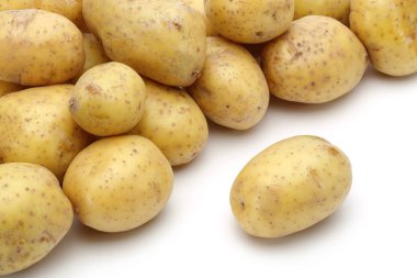 Beyaz arka plan üzerinde taze bütün patates yığını