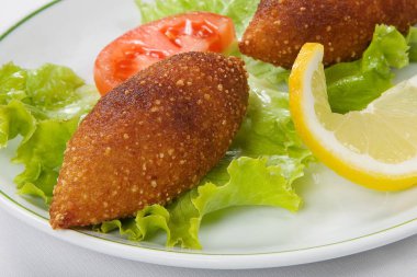 Türk içli köfte ve beyaz tabakta marul yaprakları