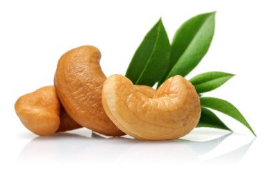 Kavrulmuş kaju fıstığı ve yaprak üzerinde beyaz izole