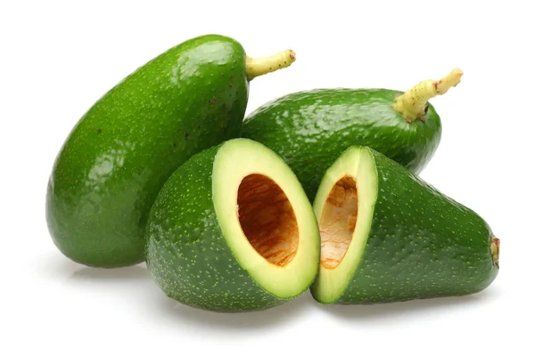 Aguacates enteros y medio verdes aislados en blanco — Foto de Stock