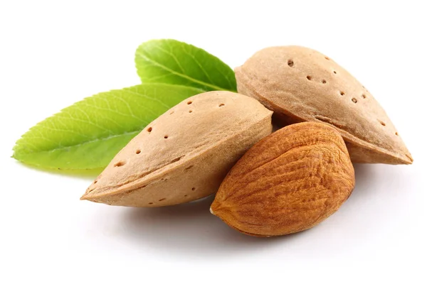 Almonds and green leaves isolated on white — Stock Photo, Image