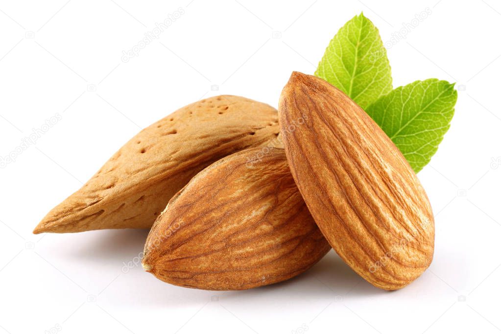 Almonds and green leaves isolated on white