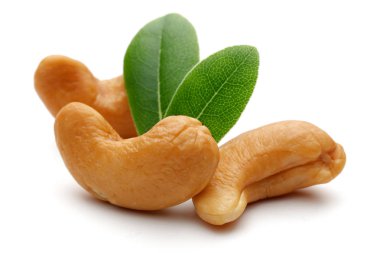 Kavrulmuş kaju fıstığı ve yaprak üzerinde beyaz izole