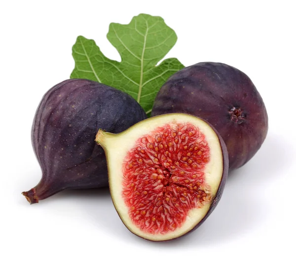 Świeży fioletowy fig owoców i plasterek z liści na białym tle — Zdjęcie stockowe