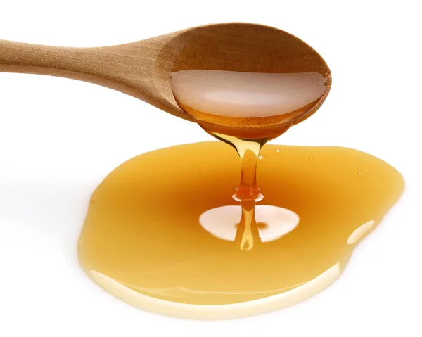 Miele gocciolante da cucchiaio di legno isolato — Foto Stock