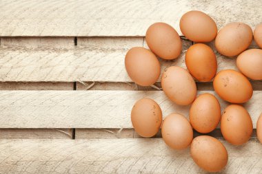 Tahta bir tahta üzerinde kahverengi tavuk yumurtası.