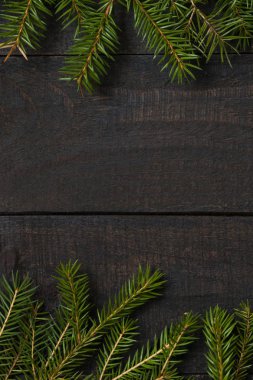 Karanlık rustik ahşap masa flatlay - Noel arka plan yeşil çam ağacı dalı çerçeve ile. Kopya metin için boş alan ile üstten görünüm