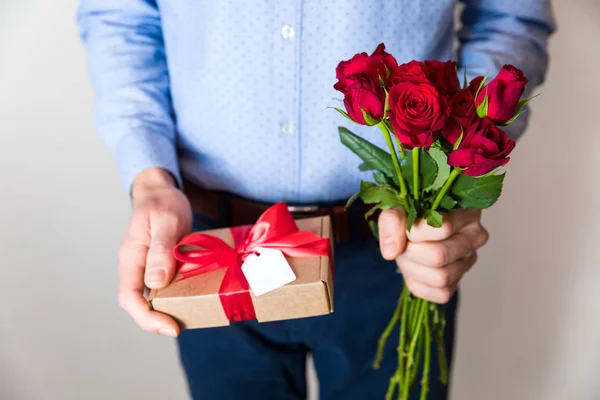 Bonito Homem Segurando Rosas Vermelhas Presente Romântico Com Arco Vermelho — Fotografia de Stock