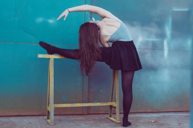 Turkuaz mavi kapı önünde, siyah elbiseli eğitim genç balerin