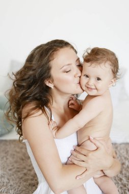 Anneler Günü 'nde küçük sevimli kızına sarılan mutlu bir anne. Kadınlar Günü. 8 Mart. Bahar selamları. Evde mutlu bir aile. Sağlıklı aile kavramı, anne ve kız bebek..