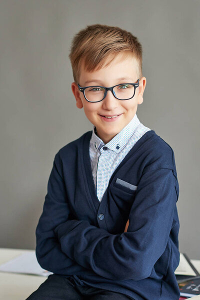 a boy with glasses doing a lesson in class doing an assignment