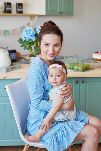 young mother and daughter cook in the kitchen