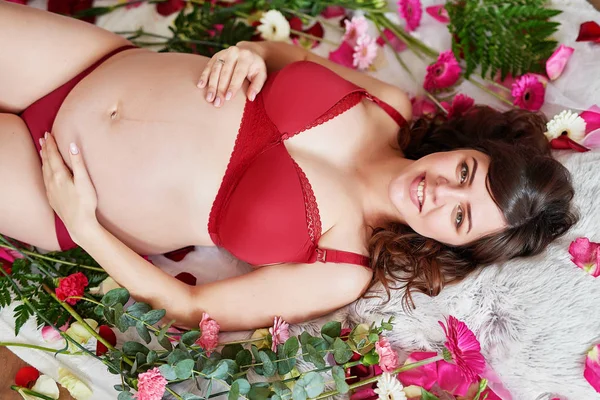 Schwangere Mädchen Roten Dessous Auf Einem Hintergrund Aus Blumen — Stockfoto