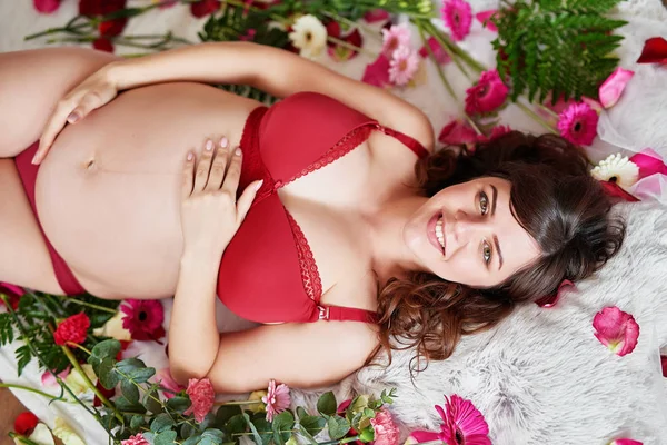 Dziewczyna Ciąży Czerwonej Bieliźnie Tle Kwiatów — Zdjęcie stockowe