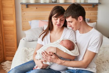 evde yatakta yeni doğmuş bir bebek ile anne