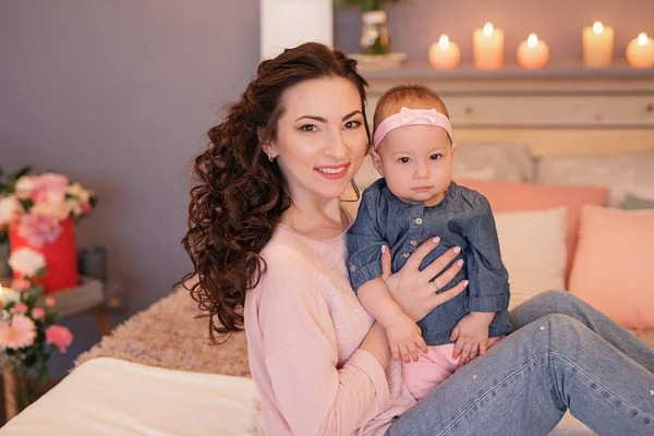 family photo session of mom and daughter on the bed with candles and flowers