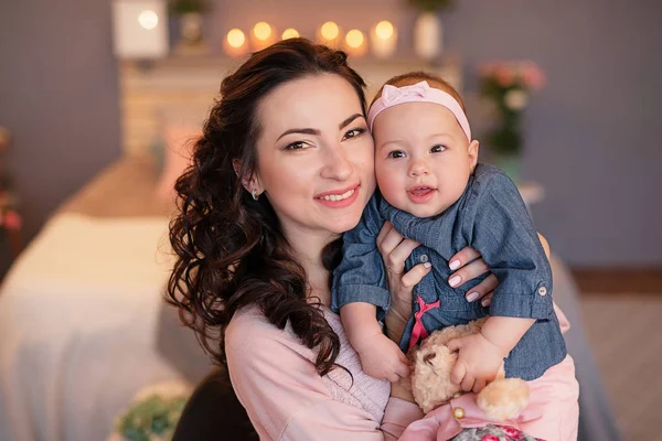 family photo session of mom and daughter on the bed with candles and flowers