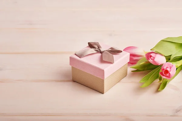 pink gift box with flowers on a light background