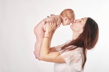 doğal makyaj ile genç anne bebek hafif bir arka plan üzerinde atış kollarını tutar