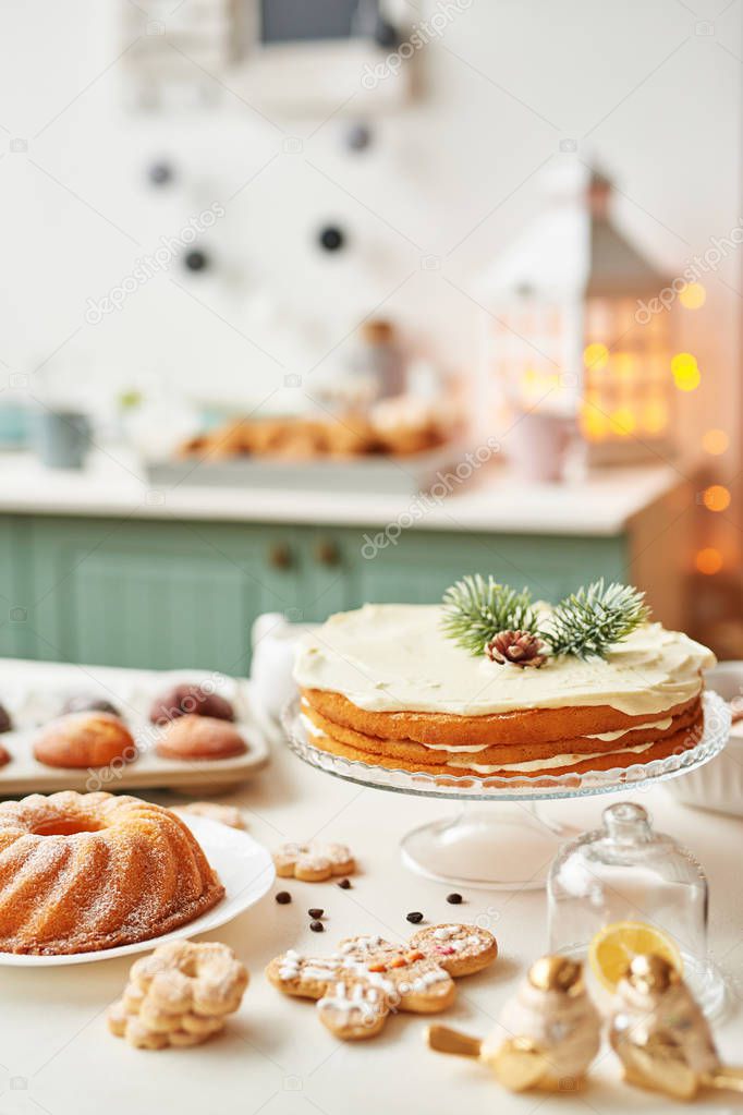 Christmas treats on the table: cupcake, naked cake, cookies and coffee with honey on the background of Christmas decorations