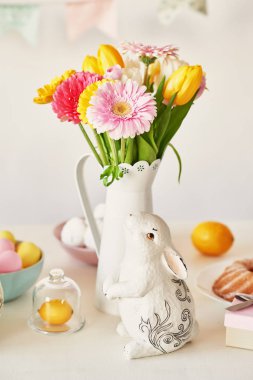 Paskalya kek, yumurta ve masaya taze çiçek tavşanlarla mutfak Paskalya için dekore edilmiştir
