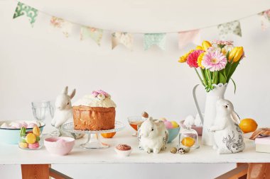 Paskalya kek, yumurta ve masaya taze çiçek tavşanlarla mutfak Paskalya için dekore edilmiştir