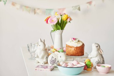 Paskalya kek, yumurta ve masaya taze çiçek tavşanlarla mutfak Paskalya için dekore edilmiştir