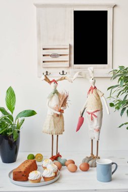 Paskalya kek, yumurta ve masaya taze çiçek tavşanlarla mutfak Paskalya için dekore edilmiştir