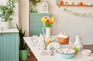 Paskalya kek, yumurta ve masaya taze çiçek tavşanlarla mutfak Paskalya için dekore edilmiştir