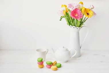 Paskalya yumurtaları ve evde mutfakta masaya canlı çiçek ile macaroons