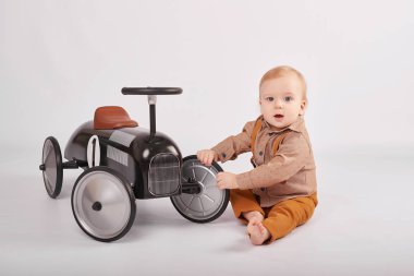 güzel bir çocuk çocuk tolocar makine ile oynarken hafif bir arka plan üzerinde