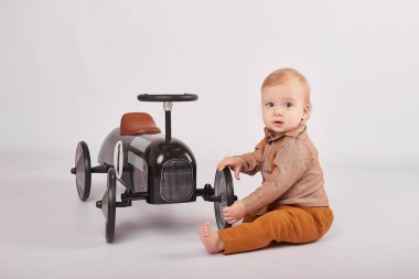 güzel bir çocuk çocuk tolocar makine ile oynarken hafif bir arka plan üzerinde