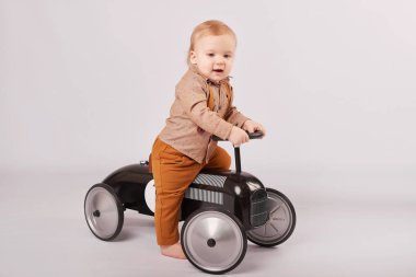 güzel bir çocuk çocuk tolocar makine ile oynarken hafif bir arka plan üzerinde