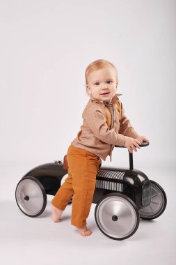güzel bir çocuk çocuk tolocar makine ile oynarken hafif bir arka plan üzerinde