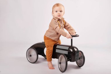 güzel bir çocuk çocuk tolocar makine ile oynarken hafif bir arka plan üzerinde