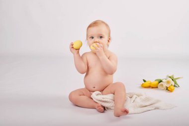 bir buket çiçek ile hafif bir arka plan üzerinde şirin yürümeye başlayan çocuk