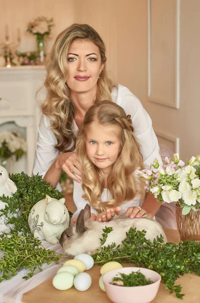 mom and daughter with bunnies at the easter table