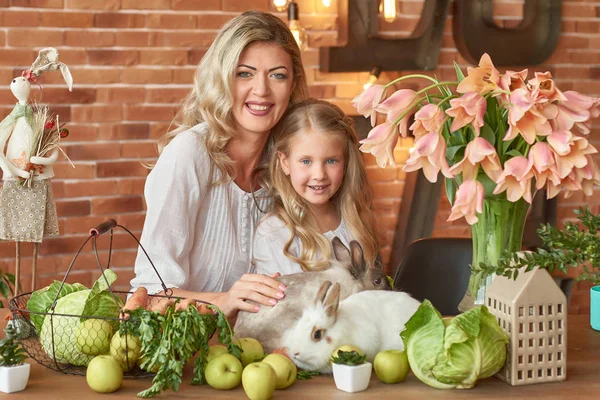 mom and daughter with bunnies at the easter table