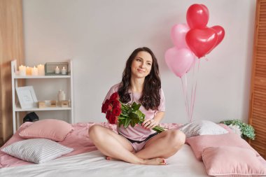 pijama genç çekici kız evde 14 Şubat Sevgililer günü için hediye yatağa açar.