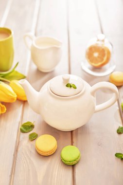Nane ve limon ile macaroons ve sarı laleler tabloda çay