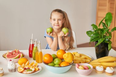 The girl eats fruit pineapple, watermelon, apples and drinks drinks from chia. Healthy food in the children's menu