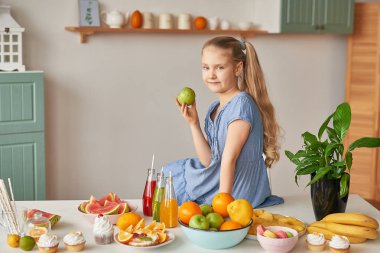 The girl eats fruit pineapple, watermelon, apples and drinks drinks from chia. Healthy food in the children's menu
