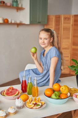 The girl eats fruit pineapple, watermelon, apples and drinks drinks from chia. Healthy food in the children's menu