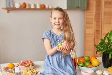 The girl eats fruit pineapple, watermelon, apples and drinks drinks from chia. Healthy food in the children's menu
