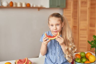 The girl eats fruit pineapple, watermelon, apples and drinks drinks from chia. Healthy food in the children's menu