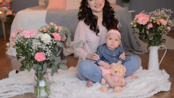 年轻迷人的母亲带着女儿在家 房子里装饰着鲜花和蜡烛 供母亲节使用 — 图库视频影像